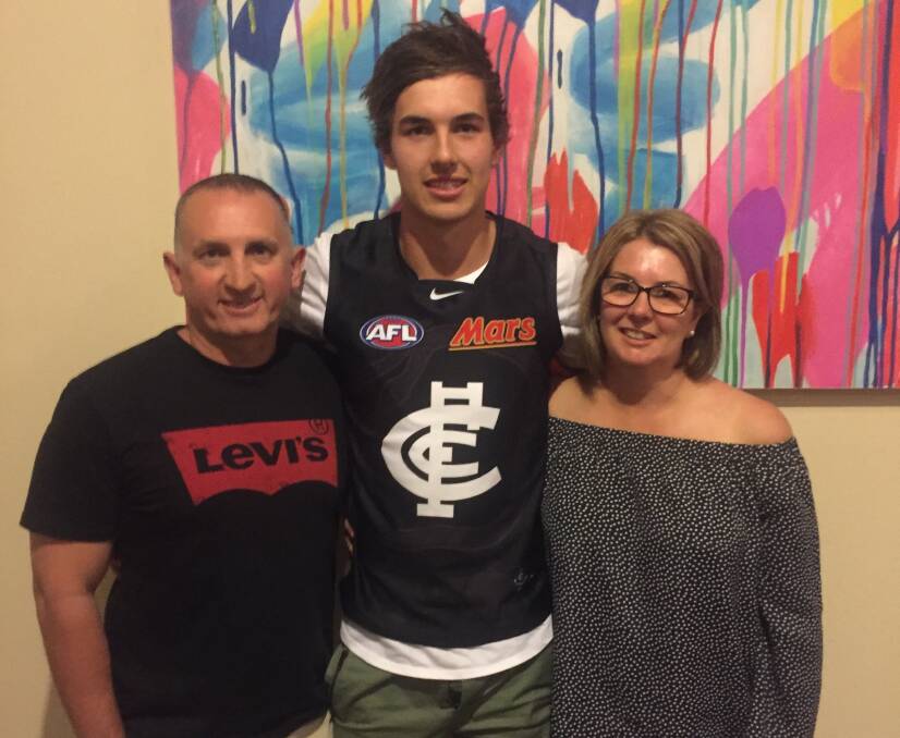 Tom Williamson tries on a Carlton jumper for the first time with dad Allister and mum Janeen. Picture: Jeremy Venosta