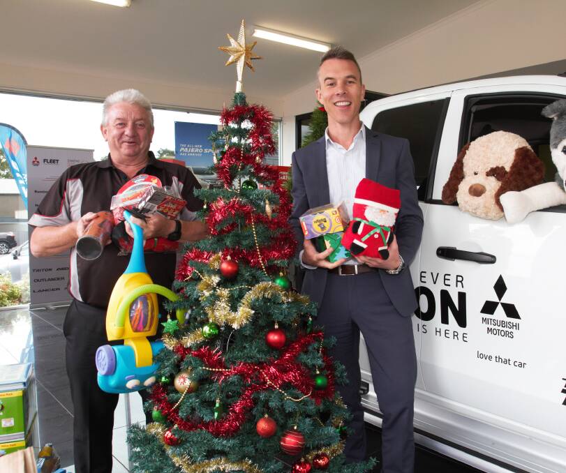 CHARITABLE: John Robertson and Michael Smith show off some of the presents already donated at Kings Cars. Picture: Peter Pickering