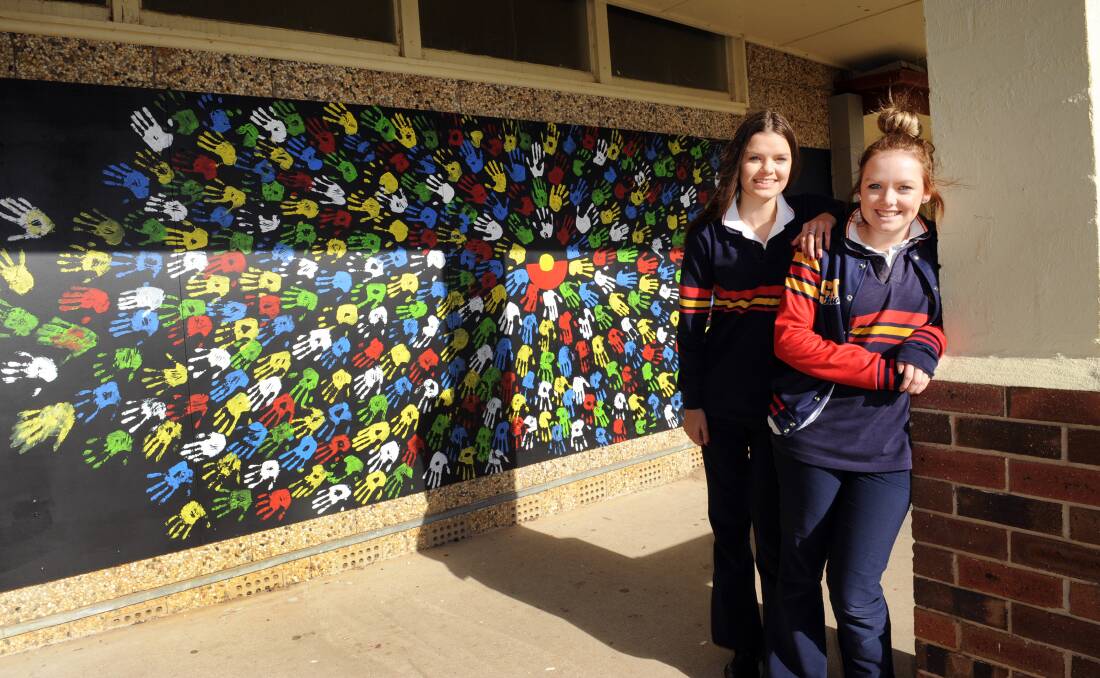 GROUP EFFORT: Stawell Secondary College students Heidi Chatfield and Chelsea Chatfield with the mural at the school. Picture: PAUL CARRACHER