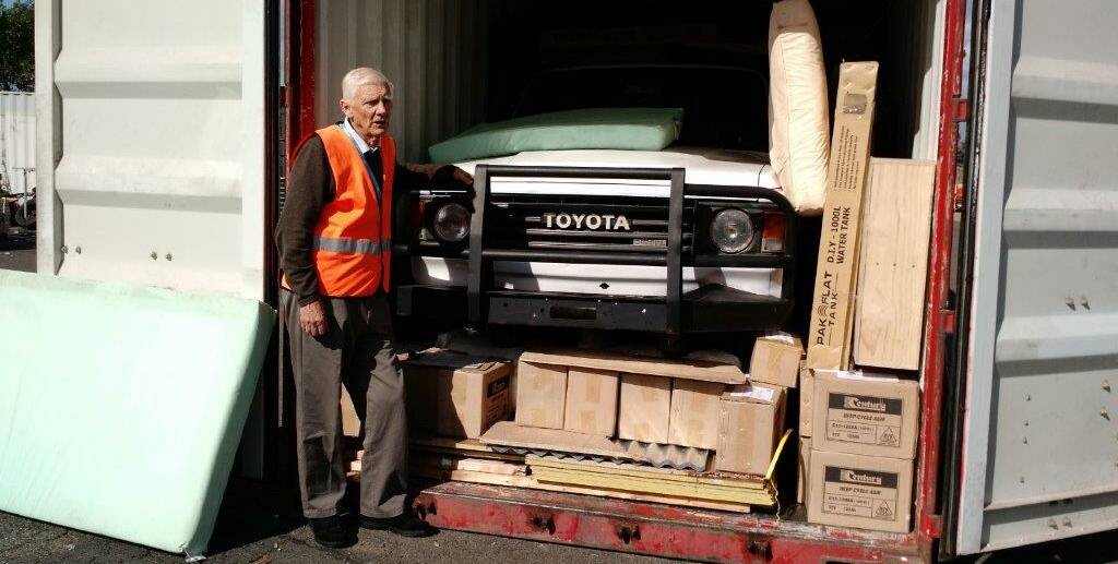READY TO SAIL: Rotarian Anton Van Doonik stands beside a container destined for Bougainville. Behind the Toyota 4WD is a tractor. Other goods are packed around the vehicles. Picture: CONTRIBUTED