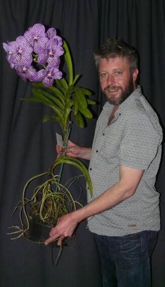 FULL BLOOM: Corey Hough was a guest speaker at a recent meeting of Stawell Orchid Scoiety. Corey is pictured with the plant of the night. Picture: CONTRIBUTED