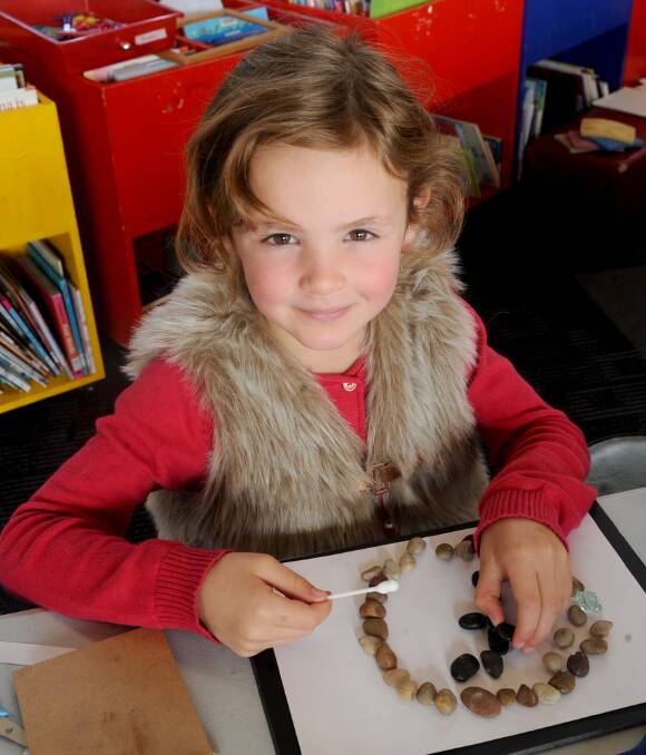 PRECISION: Isabelle Thomas, 6, of Stawell, works away on her pebble art creation at the Stawell Library. Picture: SAMANTHA CAMARRI