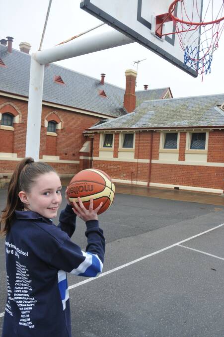 Taya Chisholm shoots for goal at her primary school. Picture: GRACE BIBBY