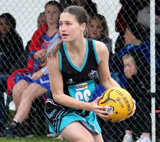 Strong hands: Darcy Crawford takes a pass on the run during the Swifts under 15 netball final.