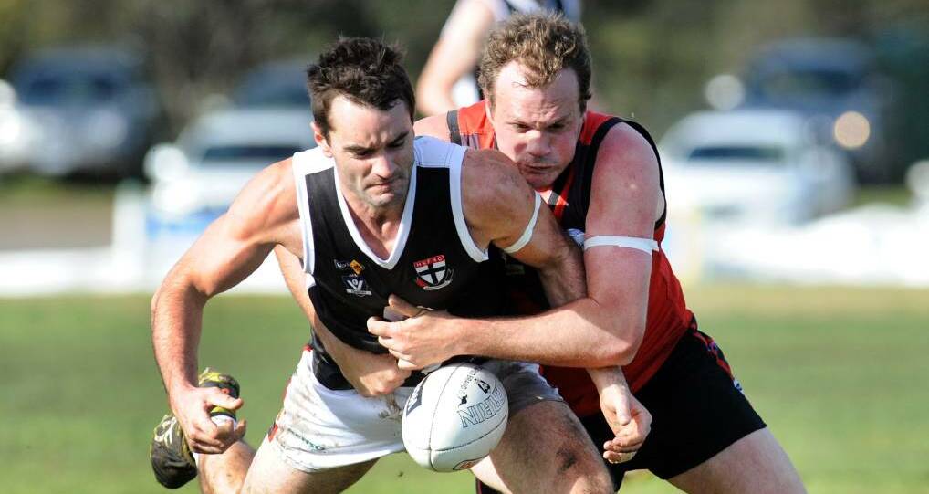 Disposessed: James Delahunty tackles Alistair Byrne during a low scoring match between Stawell Warriors and Horsham Saints at Coughlin Park. Picture: PAUL CARRACHER