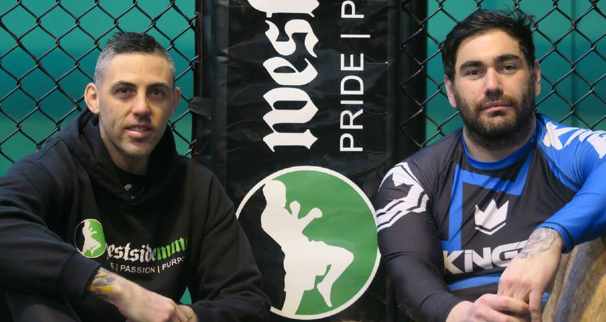Power duo: Stuart Grant, owner and coach at Westside MMA, joins athlete Jeremy Joiner, right, beside the cage during a training session midweek. Picture: Contributed.