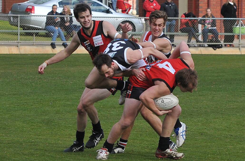 Forcing: Stawell Warriors midfielder Cam Kimber pushes through a tackle laid by a Horsham Saints opponent. Picture: Mark McMillan