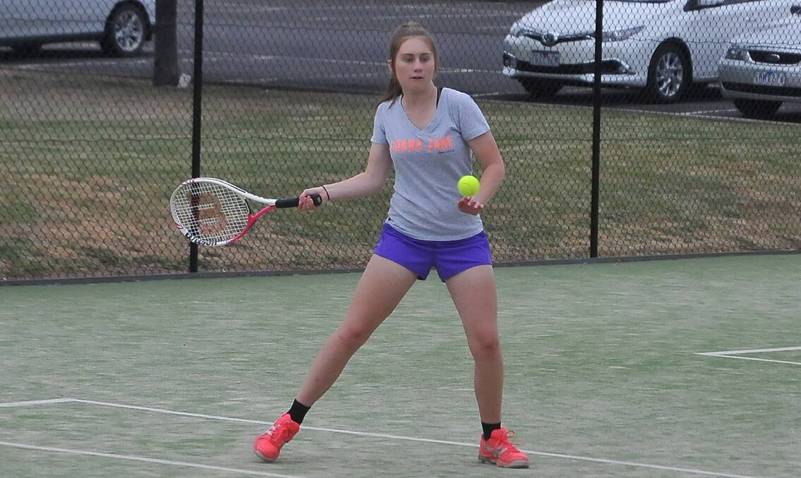 eyes on the ball: Kasey Mornane watches the ball onto her racquet during the junior tennis competition. Mornane won all three of her sets when junior tennis was played Friday night.