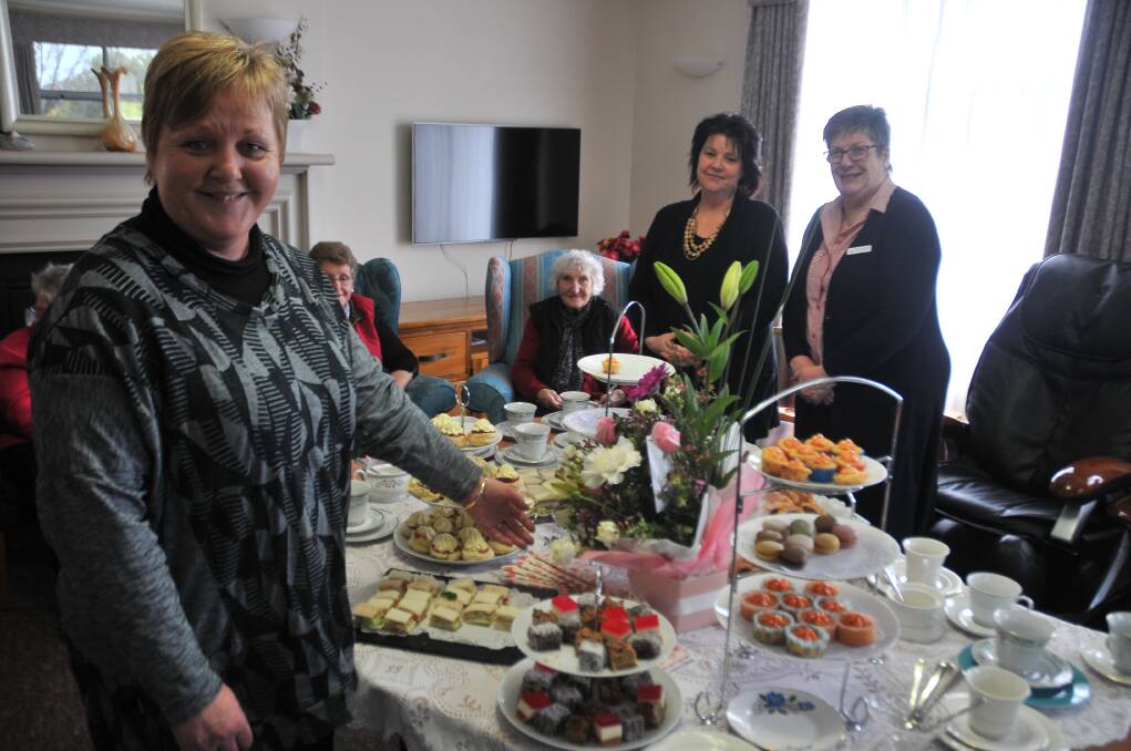 Eventide homes staff members show off their selection of afternoon dinner at a high tea celebration for Rae Fox. Picture: Grace Bibby