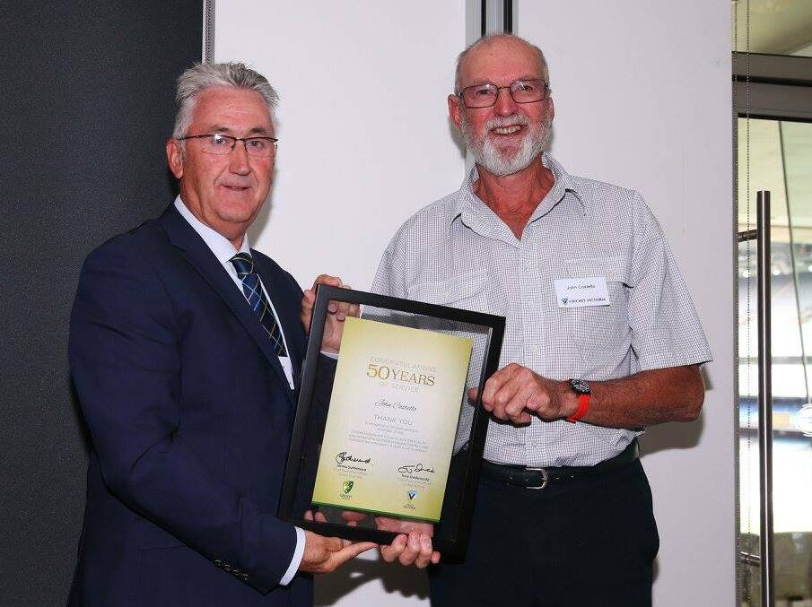  Celebrating: Russell Thomas, Chairman of Cricket Victoria, presents Navarre cricketer John Costello with his 50 years of service at a function last week.