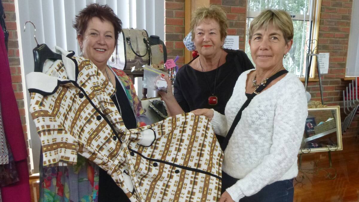 On display: Allison Rasche is pictured showing Lorraine  Millikin and Elfridda Furzer another vintage item at the Uniting Church Pop Up Shop. Picture: CONTRIBUTED.