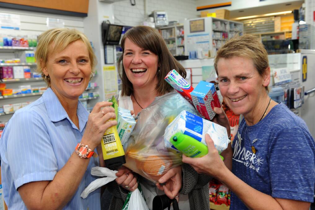 Campaign support: Grampians Pharmacy staff Susan Byron and Sue Gunnell are busy loading up campaign organiser Naomi Lovell with goods for collecting for charity Share The Dignity. Picture: PAUL CARRACHER.