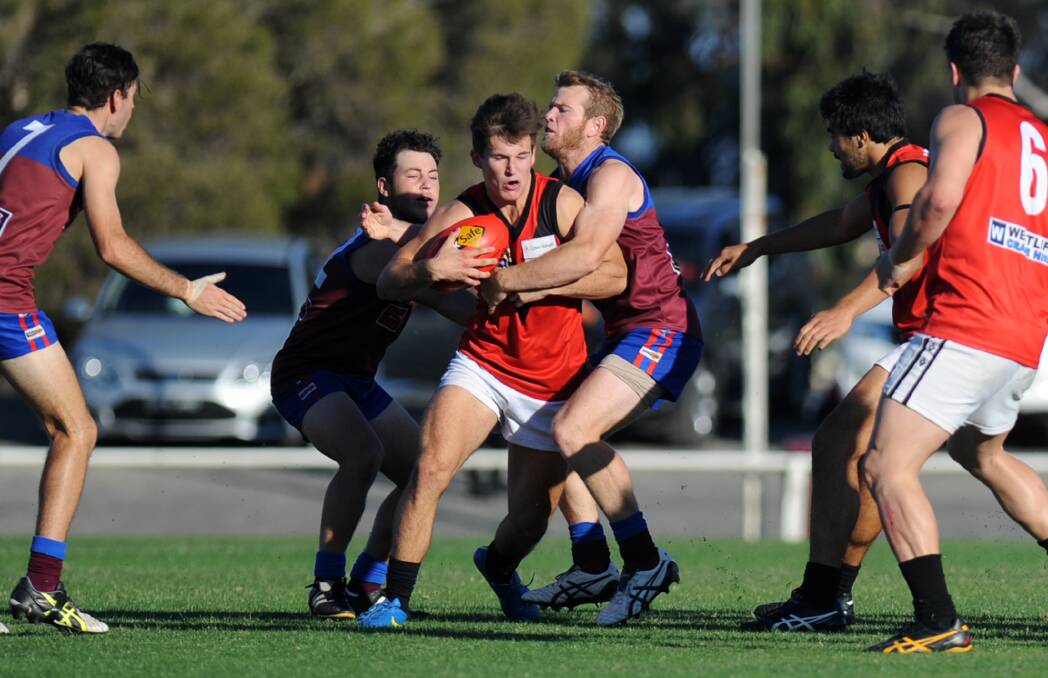 POWER: Ben Taylor attempts to break out of a tackle from Horsham Demons players Bailie Batchelor and Nic Pekin earlier in the year. Picture: SAMANTHA CAMARRI