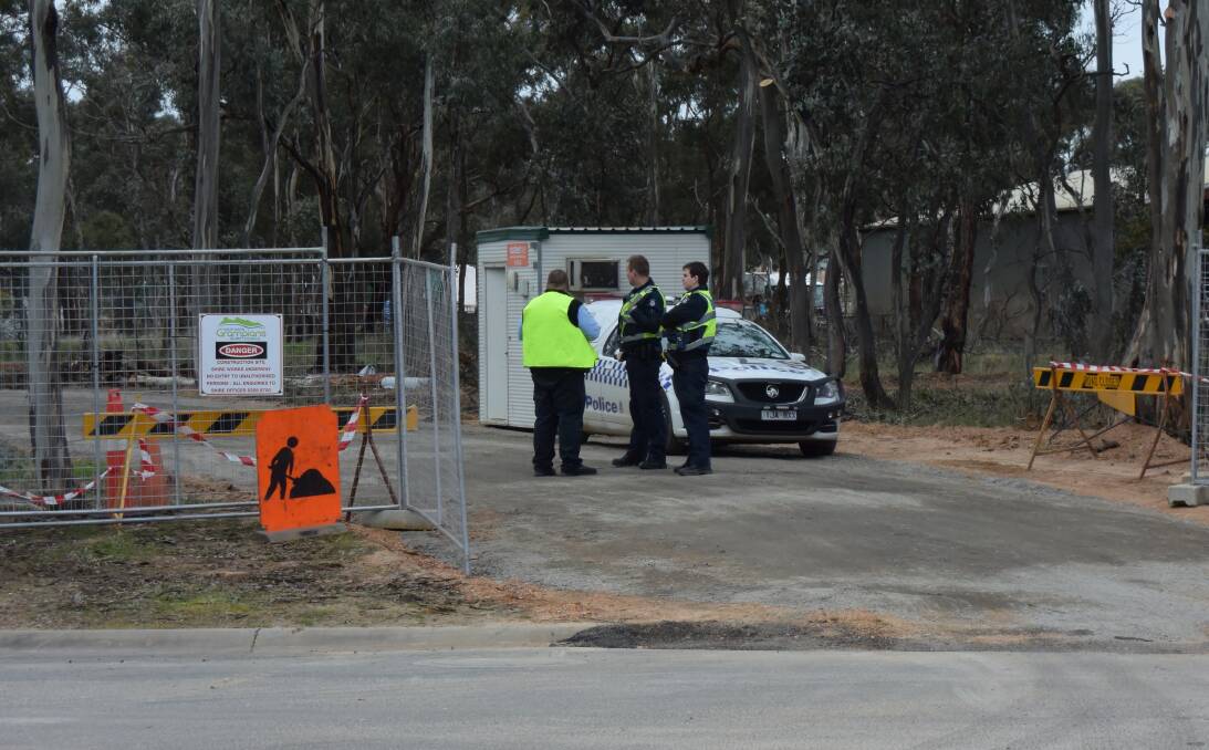 Police speak with a security guard at the Stawell tyre yard after the EPA took control of the site. Picture: REX MARTINICH