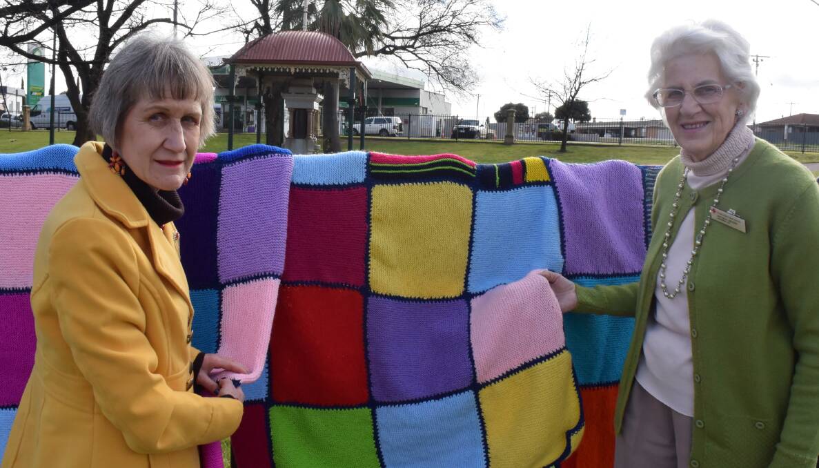 Red Cross Horsham secretary Cheryl Linke and publicity officer Rhonda Hender hold  one of the blankets made from donated squares. Picture: REX MARTINICH