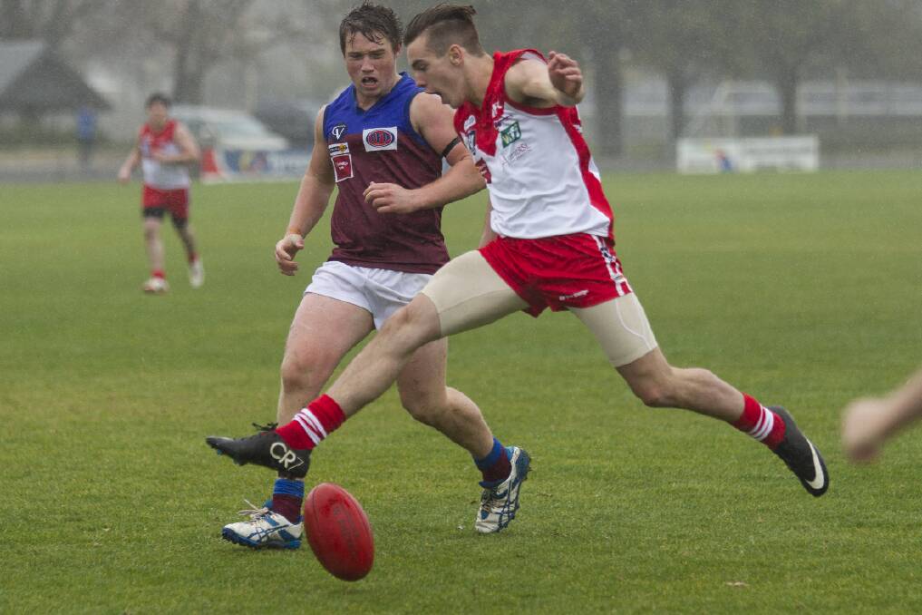 Ararat s Dom Didomernico looks to keep the ball moving forward during the reserves match in wet conditions at Alexandra Oval. Pictures: PETER PICKERING