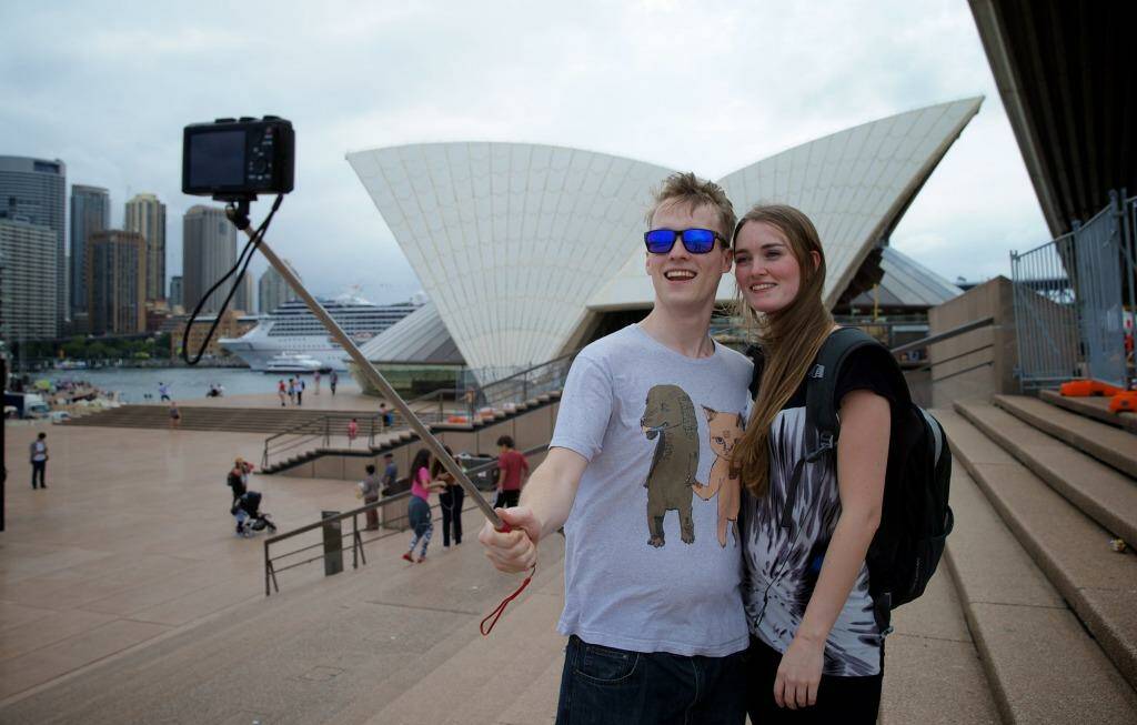 Tourists using selfie sticks. Alex Kyling and Linda Keizer use a selfie stick at the Opera House. Photo: Wolter Peeters