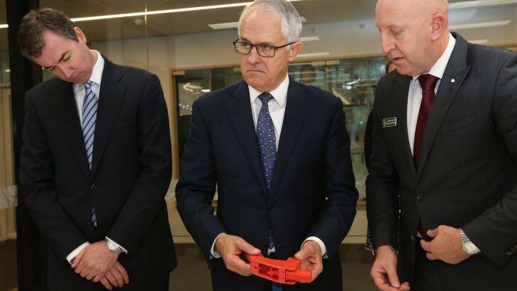 Justice Minister Michael Keenan, Prime Minister Malcolm Turnbull and AFP acting national manager of specialist operations Simon Walsh as Mr Turnbull examines a 3D printed gun. Photo: Andrew Meares