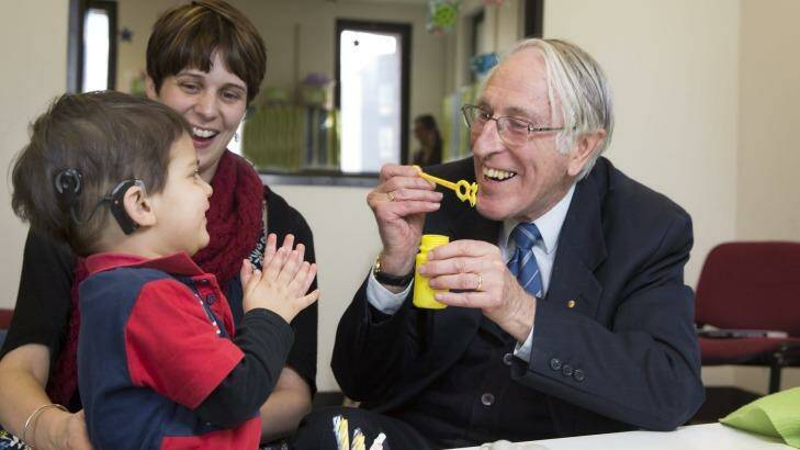 Graeme Clark who invented bionic ear with 2yr-old Declan Zemora who has just got his hearing. Photo: Fiona Hamilton