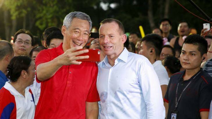 Time for a selfie ... Tony Abbott, right, with Singapore Prime Minister Lee Hsien Loong attend the '50 BBQ' event at Bishan Park, Singapore.  Photo: Brad Hunter