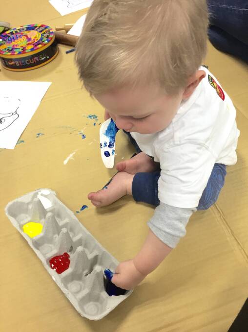 Blake is busy painting during the Playgroup session.
