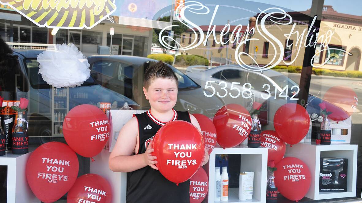 Ryan with a ‘Thank You Fireys’ red balloon outside Shear Styling in Stawell where NRBD merchandise can be purchased. Picture: BEN KIMBER