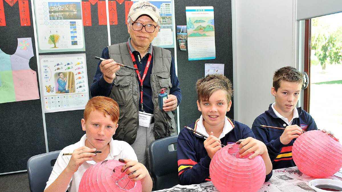 Stawell Secondary College celebrated the Chinese New Year. Preparing for the celebrations during a Chinese language class are students (l-r) Joesph, Sam and Beau with visiting artist Yong-jin Zhao. Picture: KERRI KINGSTON.