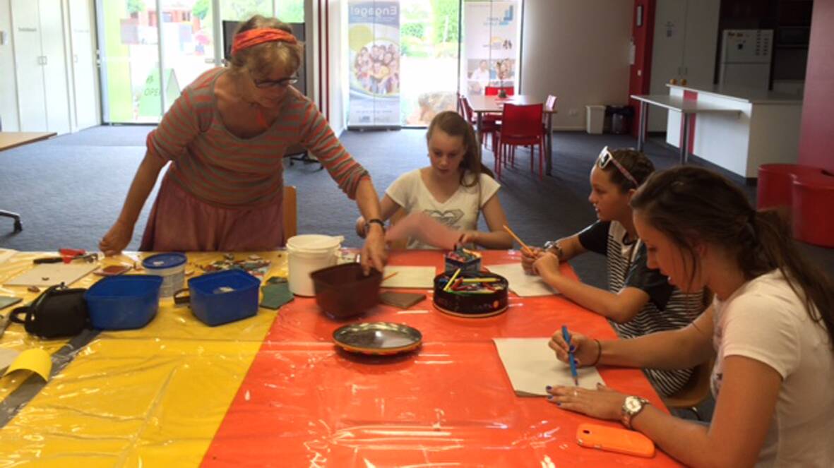Artist Bev Isaac with students Tayla, Kaylee and Mollie making mosaics.