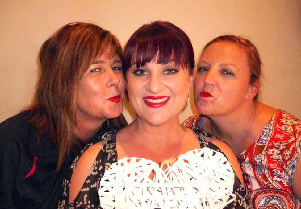 Hello Gorgeous owner Kim Salmi (centre) receieves a kiss from Melissa Vos (left) and Lydia Kindred, as they prepare to paint the town red in support for the annual Kiss MS goodbye campaign.