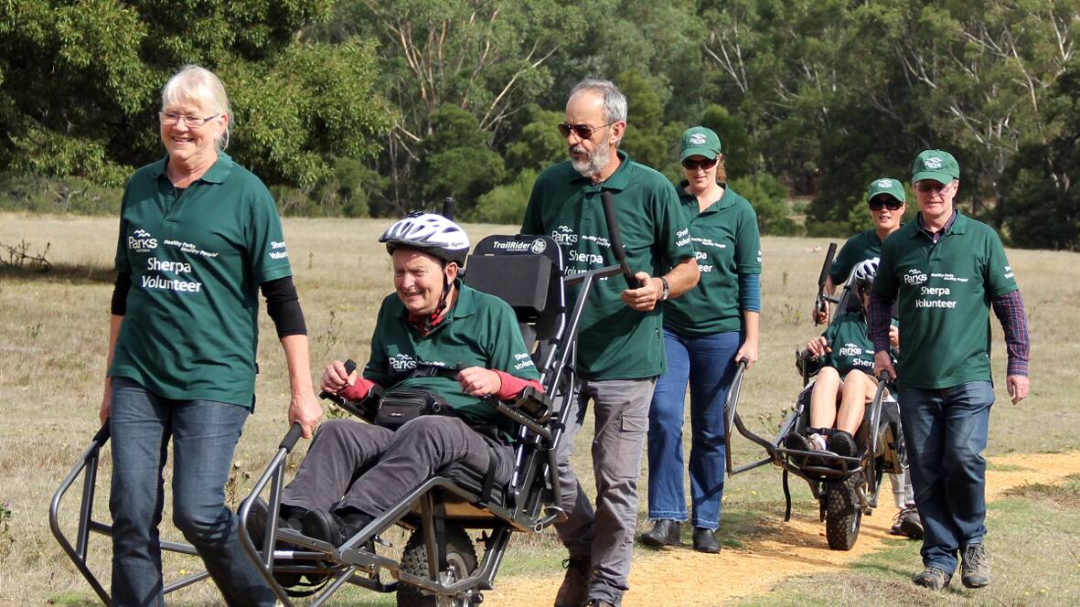 David Stratton (in the front wheelchair) is joined by Gilda McKechnie at the front and other volunteers from the sherpa program, enjoying the Grampians National Park.