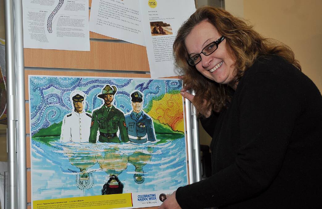 Suzie Hamilton, Aboriginal Community Development Officer, hangs a painting as part of activities to mark NAIDOC Week. Picture: KERRI KINGSTON.