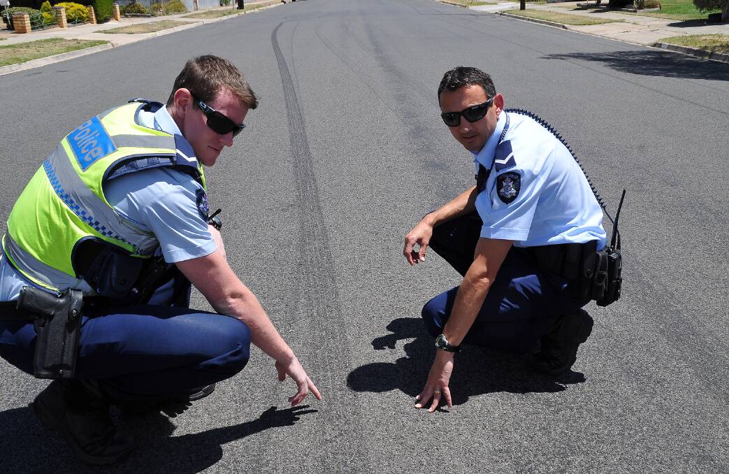 Stawell Police First Constables Aaron Carasse (left) and Jamie Bennett examine skid marks on a road in Stawell left by a hoon driver. Picture: MARCUS MARROW.