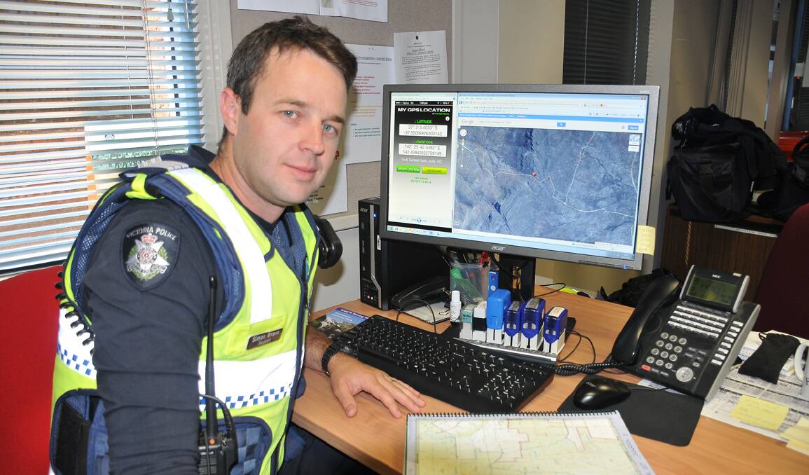 Stawell police Sergeant Simon Grant is pictured at his desk where he communicated with a Sydney couple who became stranded in the Grampians on Monday. A phone application allowed the pair to email him screenshots of their position and GPS coordinates. Picture: BEN KIMBER