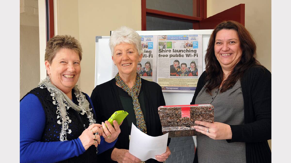 Lynette Healy and Maree Dobson learn how to log onto the free Wi-Fi from Shelly Chalmers.