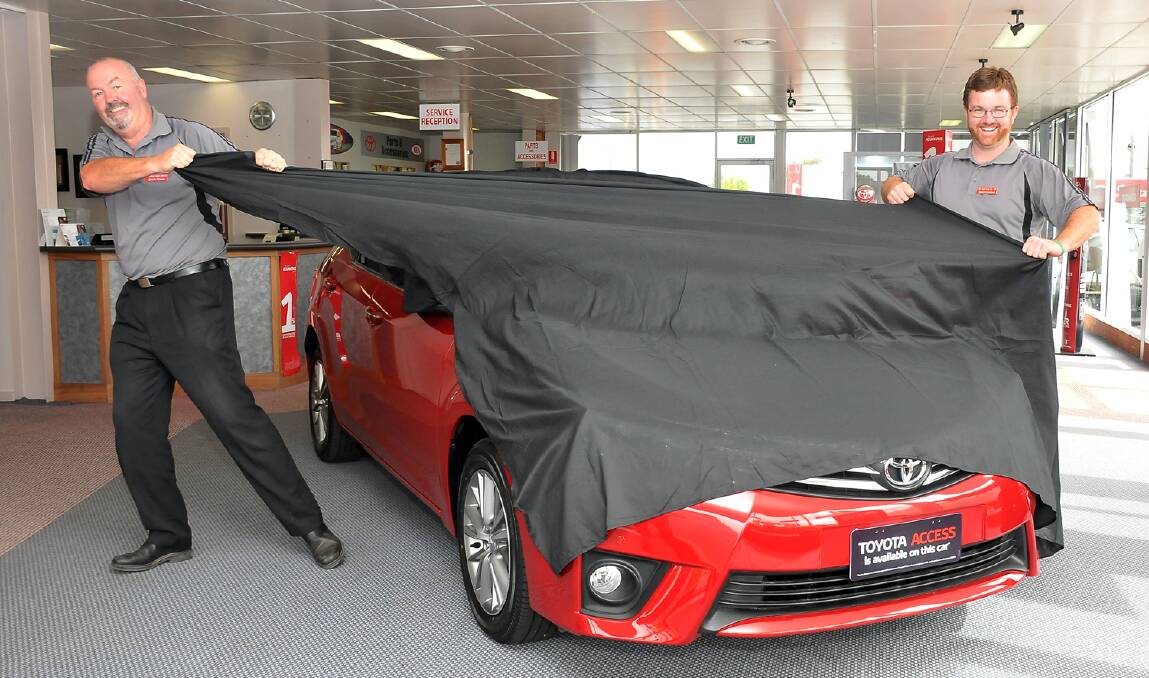 Jamie Erwin and Daniel Crawford from Stawell Toyota, prepare to unveil a new car on Sunday.