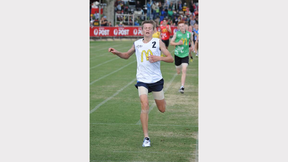Nicholas Rayson crosses the finish line first in the little athletics event on Sunday.