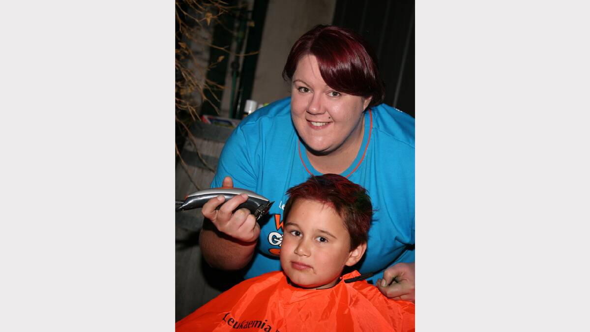 Youngster Austin Tyers prepares to have his head shaved by Brooke Dunn during the fundraising event.