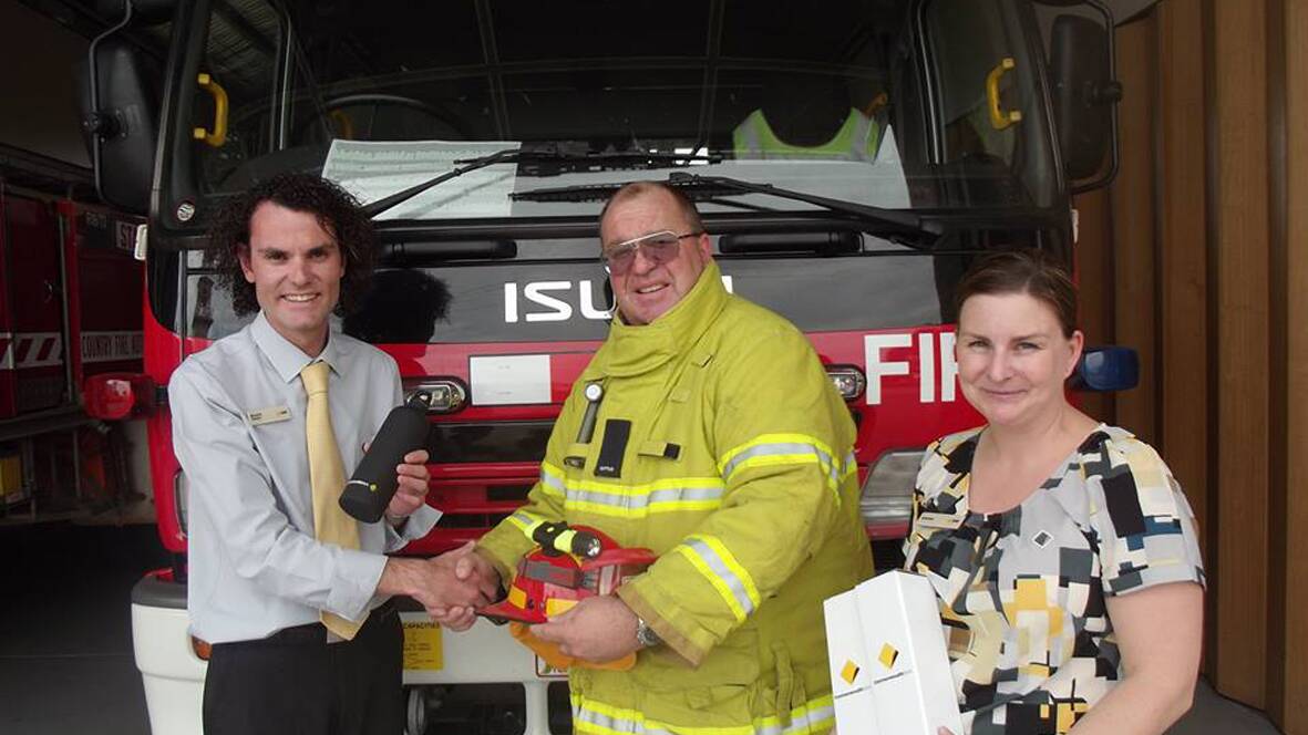 Daniel Jones (left) and Lauren Reading (right) present the stainless steel drink bottles to Stawell Fire Brigade Captain, Tim Hughes.