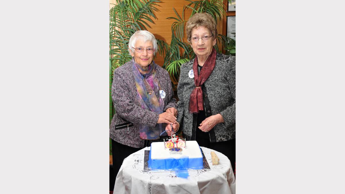 Joyce Matheson and Eline Beelitz cut the birthday cake.