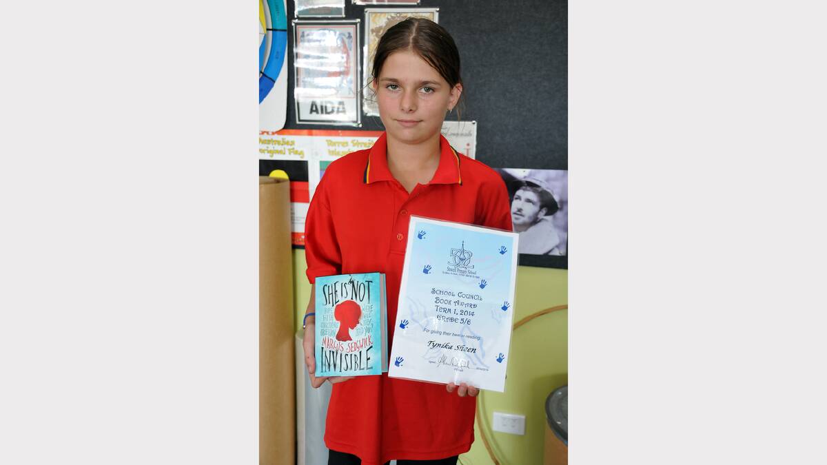 Tynika with her book award and a copy of She Is Not Invincible.
