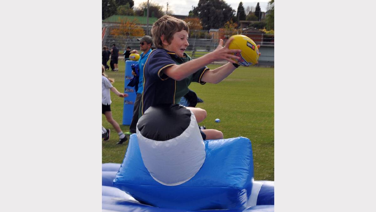 Kyle Dignan takes a big grab over the inflatable during the visit by the Hawthorn players.