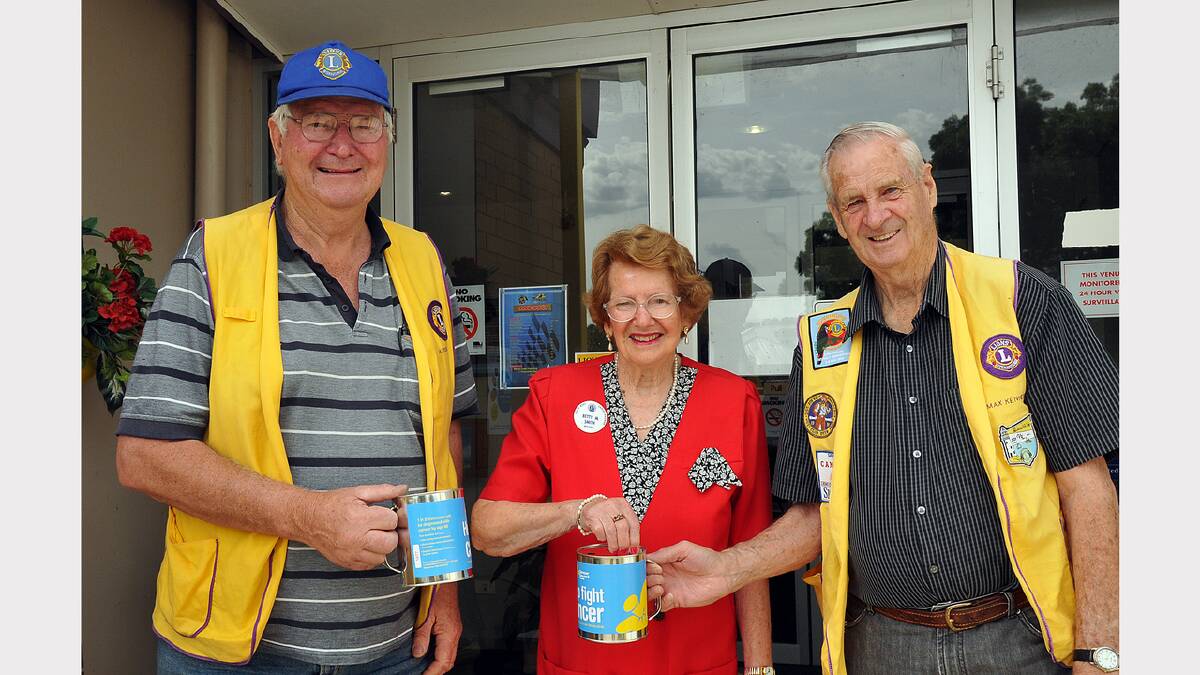 Lions members Ian Taylor and Max Kennedy collect some coins from Betty Smith at the Trackside Tabaret last year.
