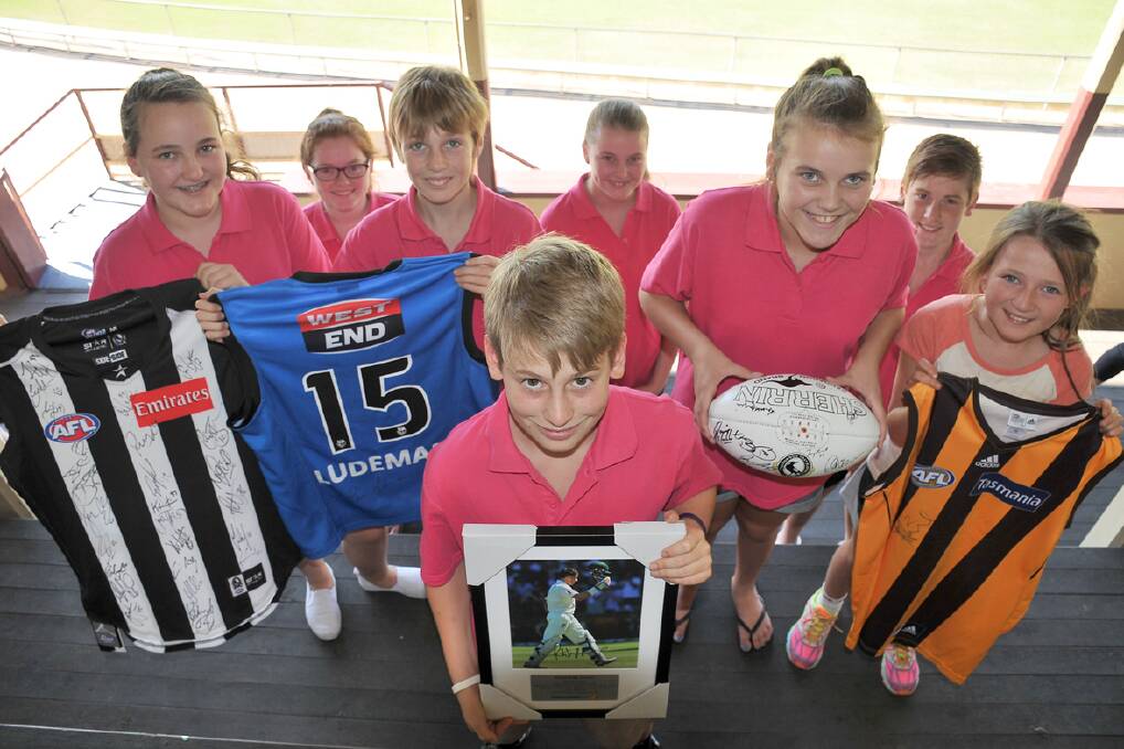 Pictured with memorabilia for the Leisa Cassidy fundraiser this Sunday are (back) Sadie, Bronte, Hamish, Madison, Caitlin, Brady, Bonnie; (front) Kain.