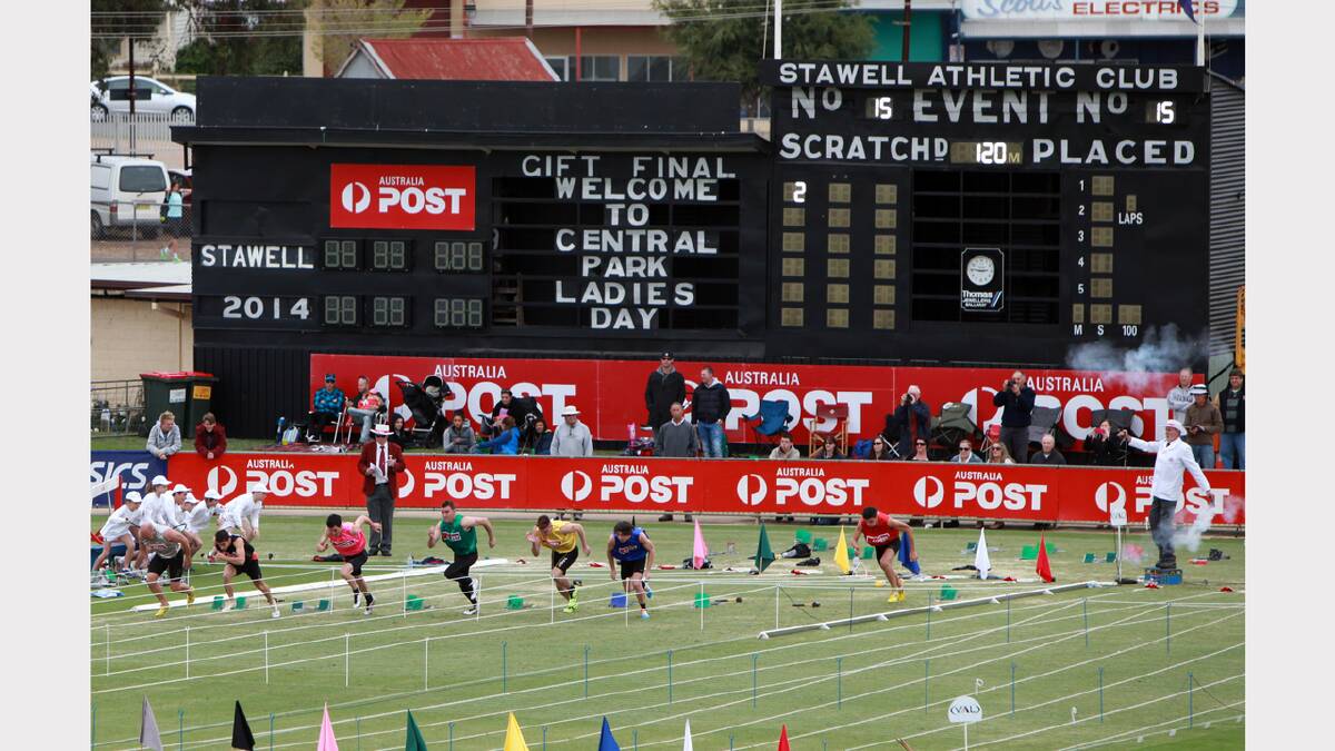 The smoke bellows out of both guns the starter Maurice Campbell holds, to signal a false start in the 15th heat of the Australia Post Stawell Gift.