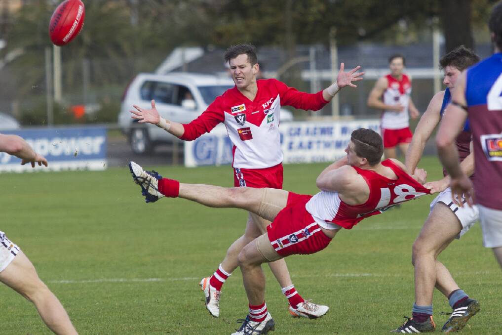 An upended Jack Ganley gets his kick away. Pictures: PETER PICKERING