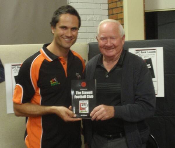 Gavin Wanganeen, who was a special guest at the launch of the book detailing the history of the Stawell Football Club, is pictured accepting a copy from author and historian, Jim Melbourne.