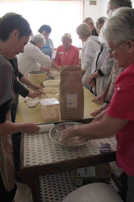Bronwyn Bant (left) is pictured taking Estelle Hirst and other participants through some practice kneeding dough, as part of the sourdough making workshop.