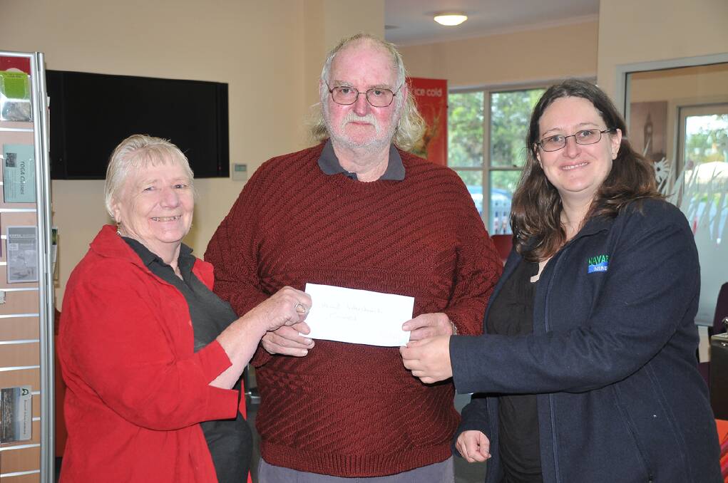 Grampians Wildflower Ride committee member Graeme Anyon presents a cheque to the value of $2000 to Stawell Interchurch Council members Kaye Dalton and Jodi Ford.