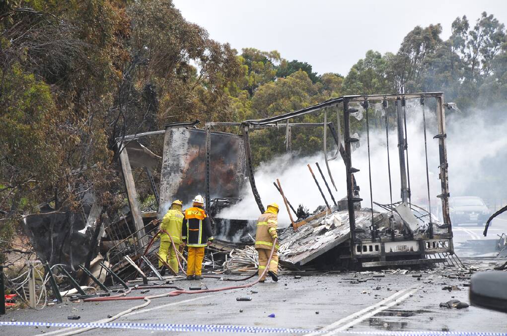 The wreckage of the trucks continues to smoulder more than 12 hours after the crash. Pictures: BEN KIMBER