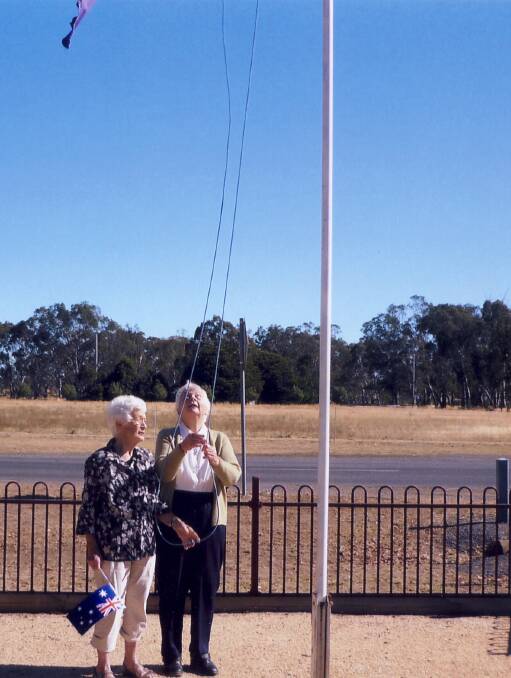 Carol Kelleher and Jean Bibby raise the flag at the beginning of the Australia Day ceremony at Navarre.